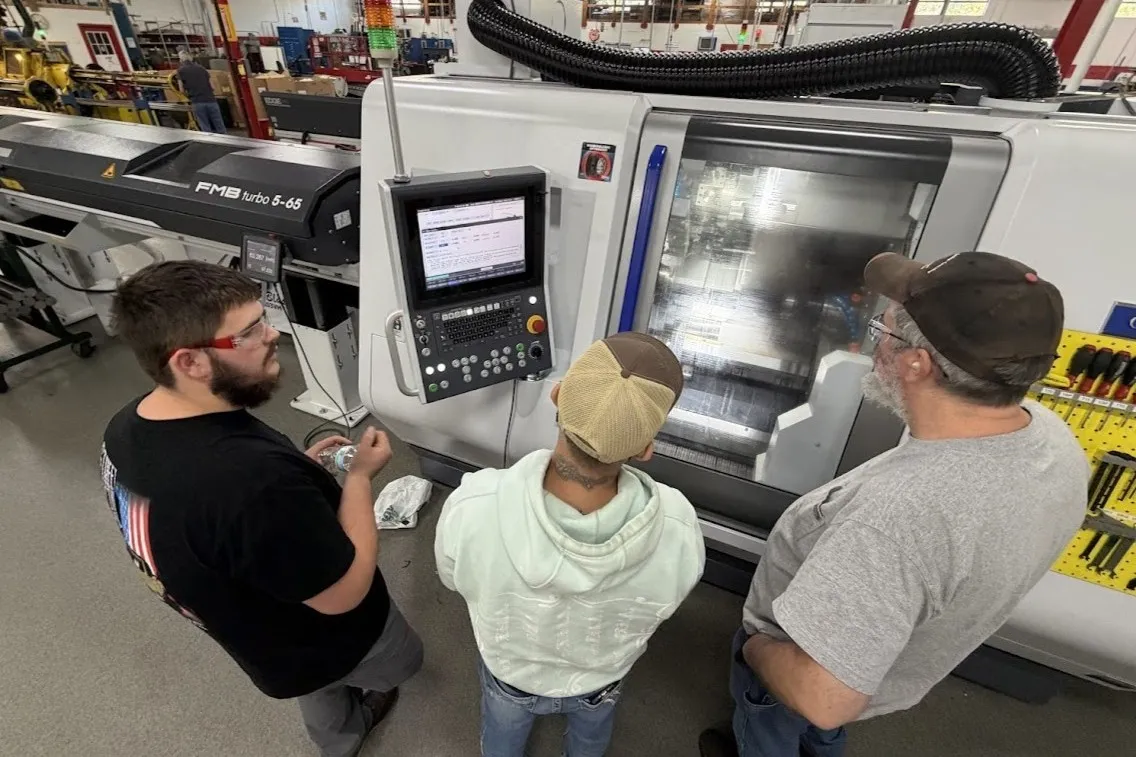 Machinists training on a Miyano BNE 65 conventional CNC lathe.
